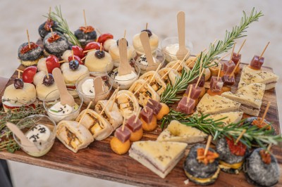 Miniature Traiteur Saint-Vallier-de-Thiey (Alpes-Maritimes) - Traiteur D'azur #5 Un cuisinier en tenue noire prépare des légumes dans une poêle en extérieur, devant un mur en pierre.