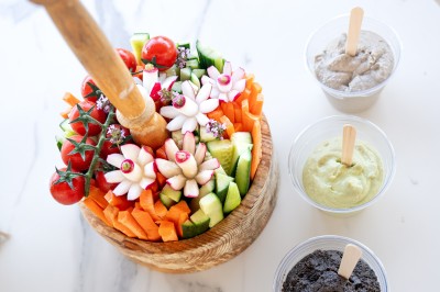 Miniature Traiteur Saint-Vallier-de-Thiey (Alpes-Maritimes) - Traiteur D'azur #9 Un cuisinier en tenue noire prépare des légumes dans une poêle en extérieur, devant un mur en pierre.