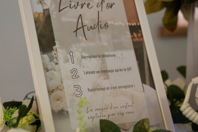 Un homme en chemise rayée bleue utilise un téléphone fixe dans une pièce ornée de décorations classiques.
