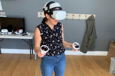 Un homme utilise un casque de réalité virtuelle avec des manettes dans une pièce équipée de crochets muraux.