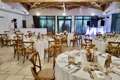 Assiette avec un morceau de viande nappé de sauce, purée, garniture de légumes et fleur comestible en décoration.