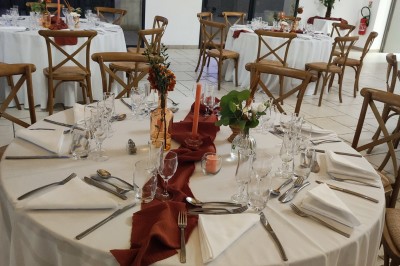 Assiette avec un morceau de viande nappé de sauce, purée, garniture de légumes et fleur comestible en décoration.