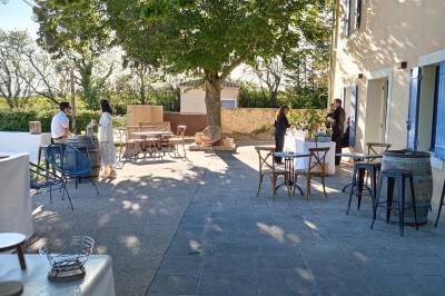 Assiette avec un morceau de viande nappé de sauce, purée, garniture de légumes et fleur comestible en décoration.
