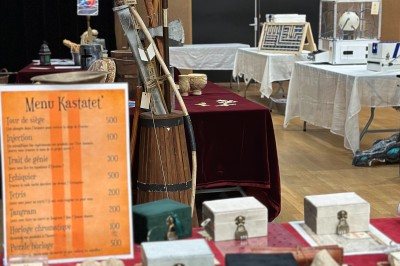 Miniature Mk Team Building #2 Des personnes tiennent un parachute coloré avec des trous, utilisé pour une activité de groupe en extérieur sur une pelouse.