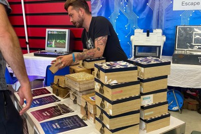 Miniature Mk Team Building #5 Des personnes tiennent un parachute coloré avec des trous, utilisé pour une activité de groupe en extérieur sur une pelouse.