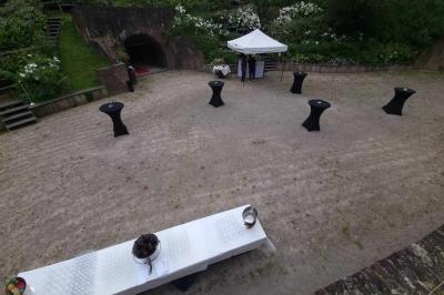 Miniature Location salle Mons-en-Baroeul (Nord) - Fort de Mons #12 Espace extérieur aménagé pour un événement avec tables hautes, buffet et tente blanche, entouré de verdure.