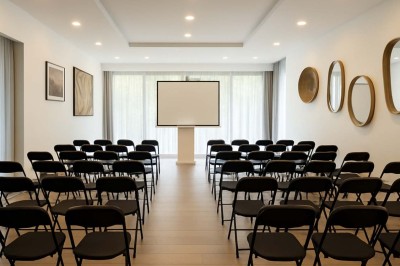 Deux fauteuils en rotin et une table basse avec une tasse, sur une terrasse donnant sur un jardin verdoyant.