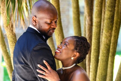 Un groupe de personnes souriantes posant ensemble devant un décor floral lumineux.