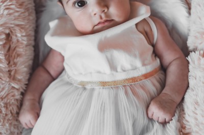 Un chanteur sur scène, vêtu de blanc, levant un bras sous des lumières de spectacle et un écran en arrière-plan.