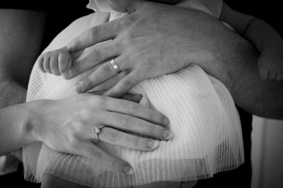 Un chanteur sur scène, vêtu de blanc, levant un bras sous des lumières de spectacle et un écran en arrière-plan.