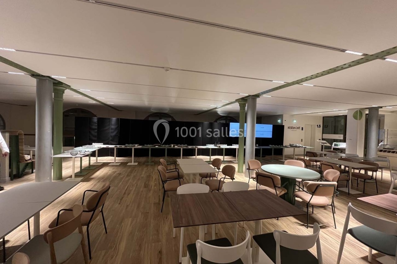 Salle lumineuse avec tables et chaises modernes, parquet en bois clair et buffet disposé en fond.