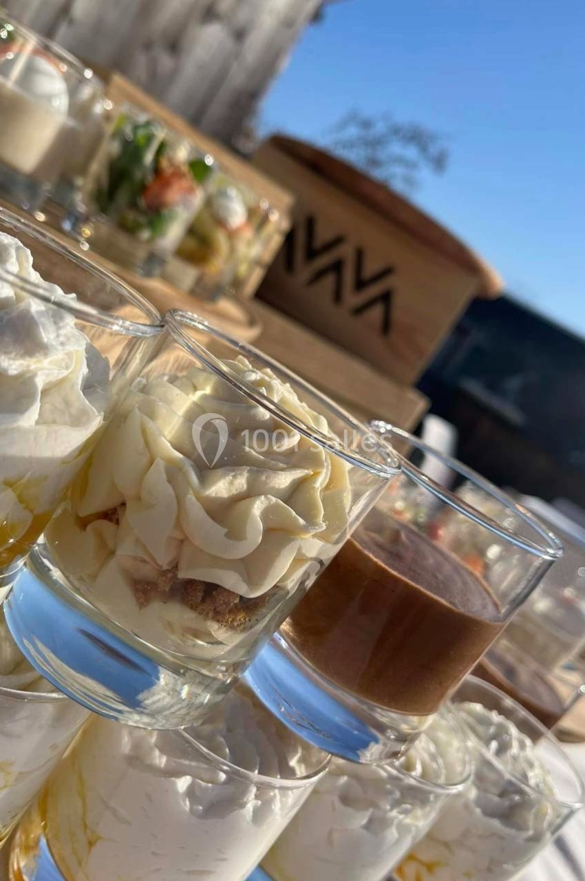 Verrines sucrées et salées disposées sur une table en extérieur, éclairées par une lumière naturelle.