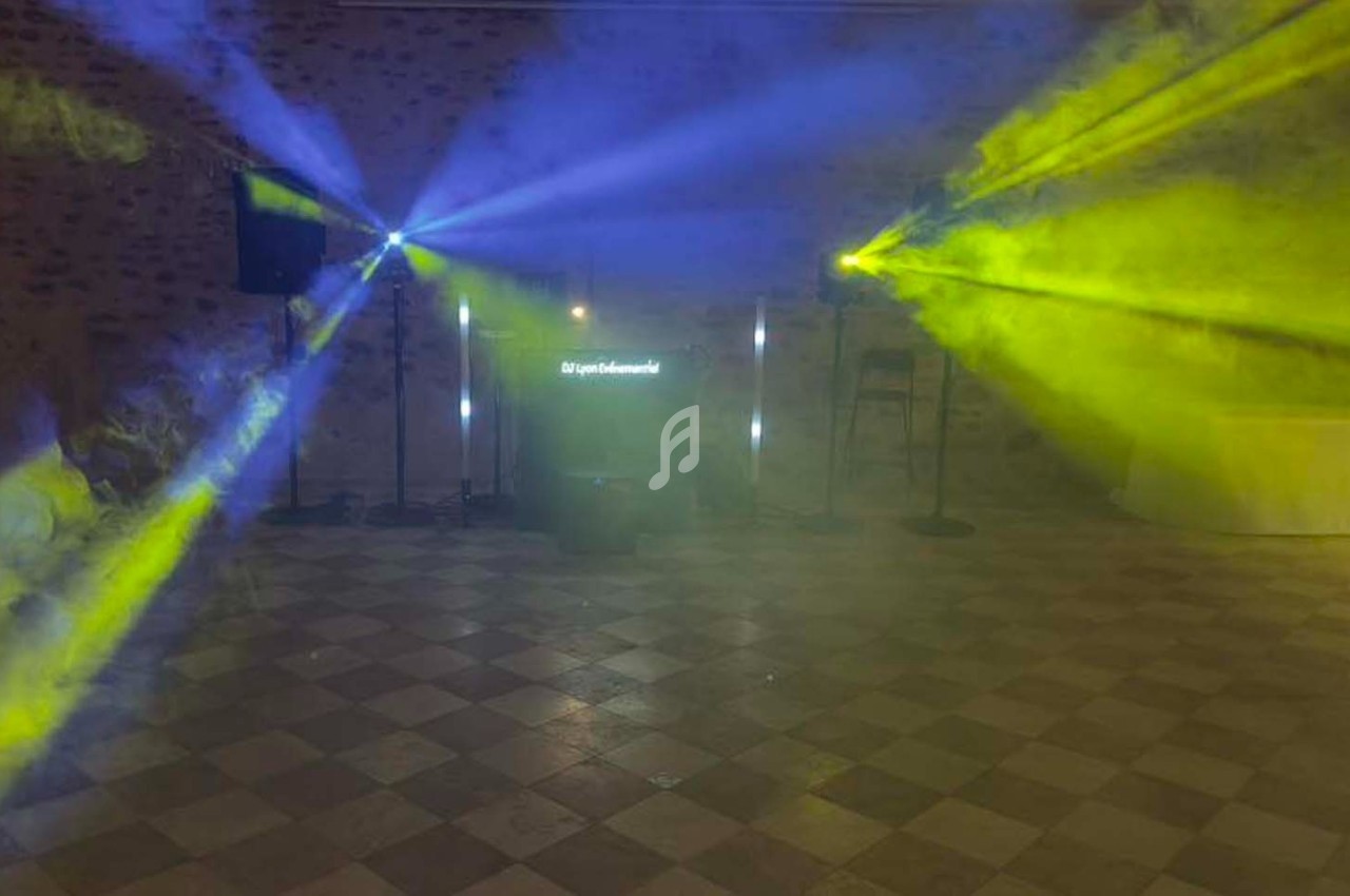 Jeu de lumières colorées bleu et jaune projetées dans une salle avec sol carrelé et murs en pierre.