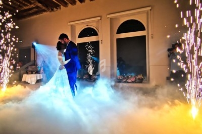 Groupe de personnes dansant sous des lumières bleues dans une ambiance festive en intérieur.