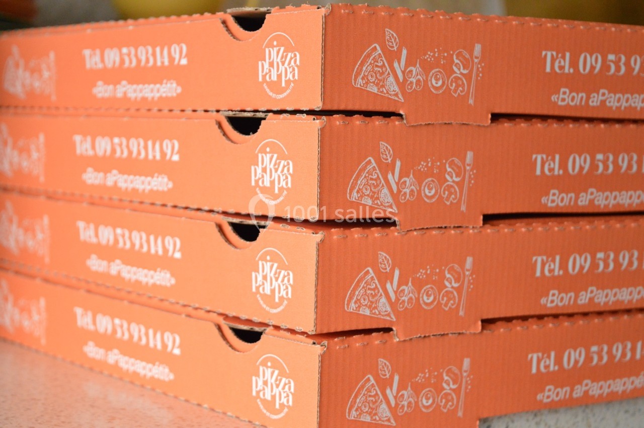 Piles de boîtes à pizza orange empilées, avec un logo, des illustrations et un numéro de téléphone imprimés.