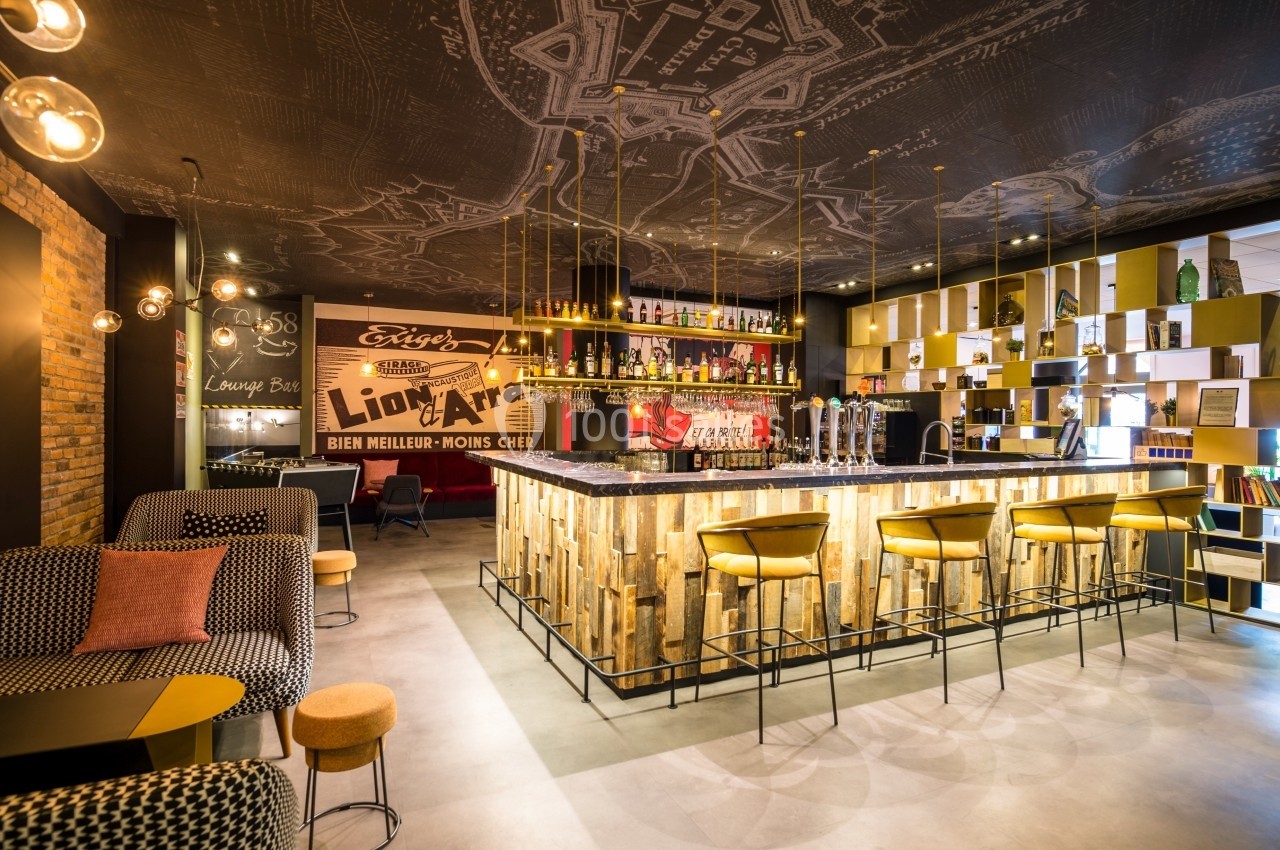 Bar moderne avec comptoir en bois, tabourets jaunes, étagères décoratives et éclairage suspendu dans une ambiance…