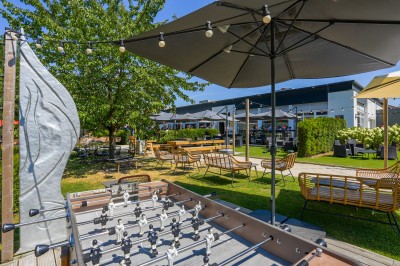 Miniature Location salle Marcq-en-Baroeul (Nord) - Mercure Lille Marcq en Baroeul #8 Salle de conférence avec des rangées de chaises colorées face à un écran de projection allumé.