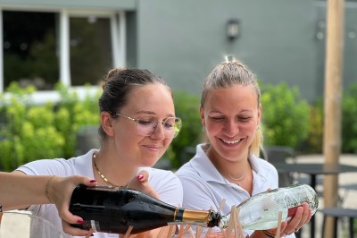 Miniature Location salle Marcq-en-Baroeul (Nord) - Mercure Lille Marcq en Baroeul #18 Salle de conférence avec des rangées de chaises colorées face à un écran de projection allumé.