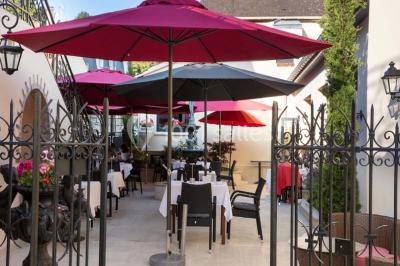 Sculpture moderne d'un taureau noir aux cornes longues et rouges, avec une posture dynamique et stylisée.