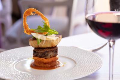 Sculpture moderne d'un taureau noir aux cornes longues et rouges, avec une posture dynamique et stylisée.