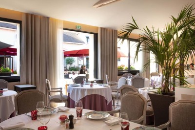 Sculpture moderne d'un taureau noir aux cornes longues et rouges, avec une posture dynamique et stylisée.