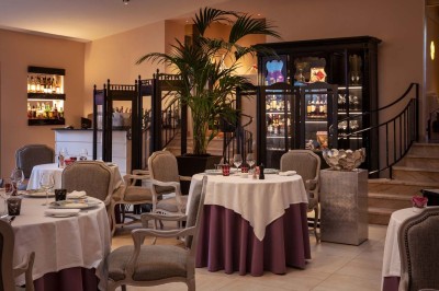 Sculpture moderne d'un taureau noir aux cornes longues et rouges, avec une posture dynamique et stylisée.