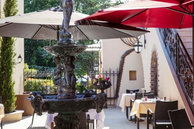 Sculpture moderne d'un taureau noir aux cornes longues et rouges, avec une posture dynamique et stylisée.