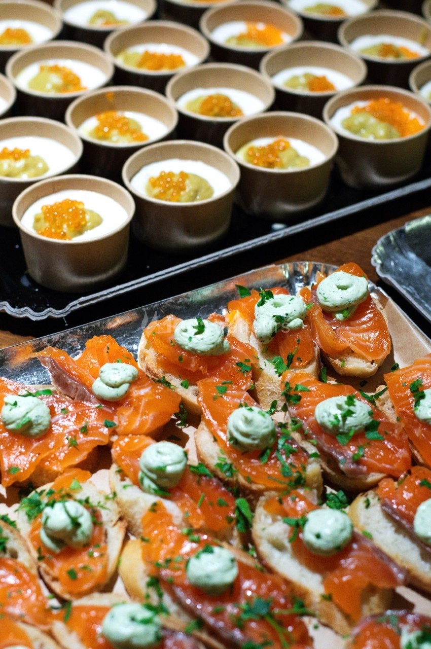 Assortiment de verrines avec œufs de poisson et toasts au saumon fumé garnis de crème verte et persil.
