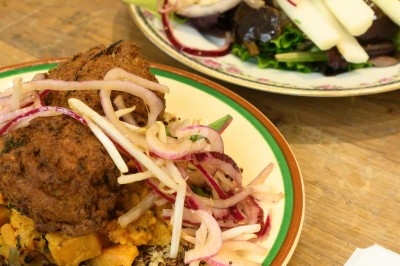 Assiette de magret de canard tranché sur purée de patates douces, garnie de persil et accompagnée d'une sauce.