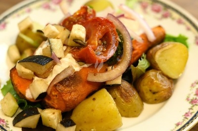 Assiette de magret de canard tranché sur purée de patates douces, garnie de persil et accompagnée d'une sauce.