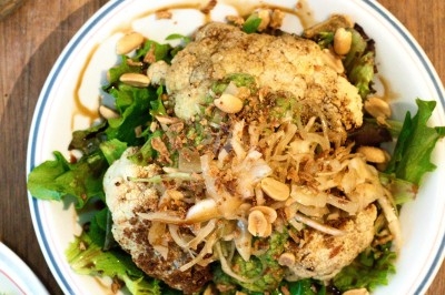 Assiette de magret de canard tranché sur purée de patates douces, garnie de persil et accompagnée d'une sauce.