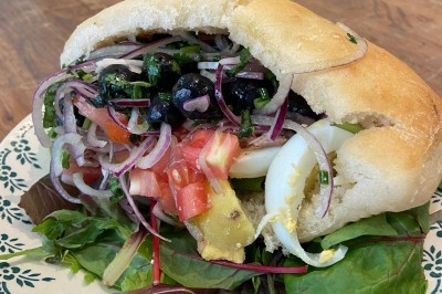 Assiette de magret de canard tranché sur purée de patates douces, garnie de persil et accompagnée d'une sauce.