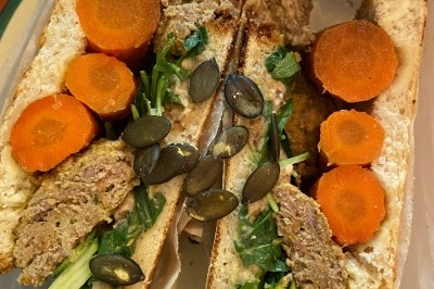 Assiette de magret de canard tranché sur purée de patates douces, garnie de persil et accompagnée d'une sauce.