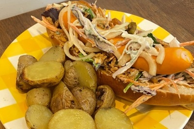 Assiette de magret de canard tranché sur purée de patates douces, garnie de persil et accompagnée d'une sauce.