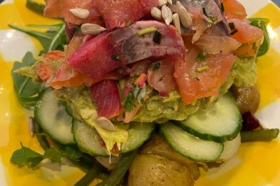 Assiette de magret de canard tranché sur purée de patates douces, garni de persil et accompagné d'une sauce.