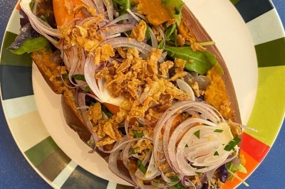 Assiette de magret de canard tranché sur purée de patates douces, garni de persil et accompagné d'une sauce.