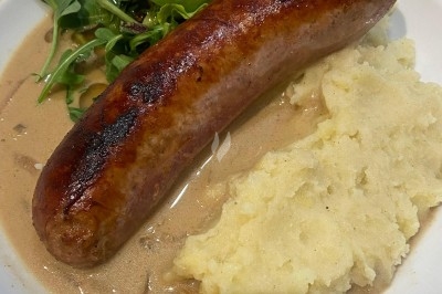 Assiette de magret de canard tranché sur purée de patates douces, garni de persil et accompagné d'une sauce.