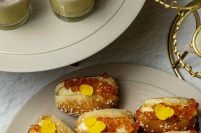 Assortiment de bouchées apéritives avec blinis au saumon et caviar, et mini-sandwichs garnis de crème et œufs de poisson.