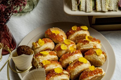 Assortiment de bouchées apéritives avec blinis au saumon et caviar, et mini-sandwichs garnis de crème et œufs de poisson.