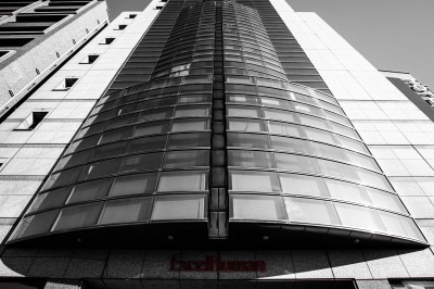 Femme assise dans une lumière tamisée, entourée de verres, regardant vers l'objectif.