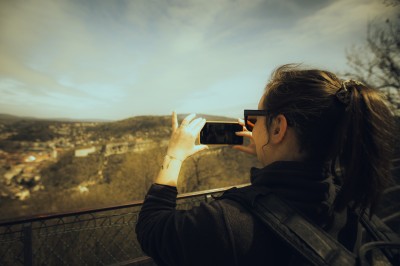 Femme assise dans une lumière tamisée, entourée de verres, regardant vers l'objectif.