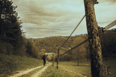 Femme assise dans une lumière tamisée, entourée de verres, regardant vers l'objectif.
