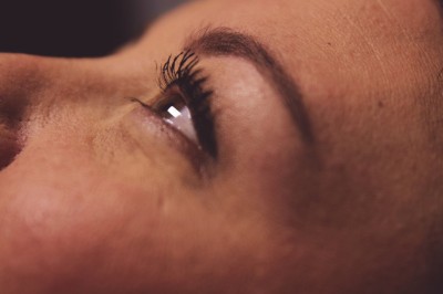 Chat tigré beige et brun bâillant, allongé sur un fauteuil bleu dans un intérieur lumineux.