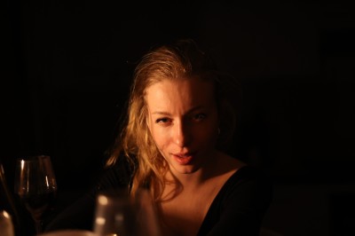 Chat tigré beige et brun bâillant, allongé sur un fauteuil bleu dans un intérieur lumineux.