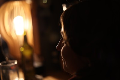 Chat tigré beige et brun bâillant, allongé sur un fauteuil bleu dans un intérieur lumineux.