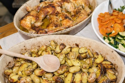 Assiette contenant une cuisse de poulet grillée, des rondelles de carottes, des courgettes et des pommes de terre rôties.