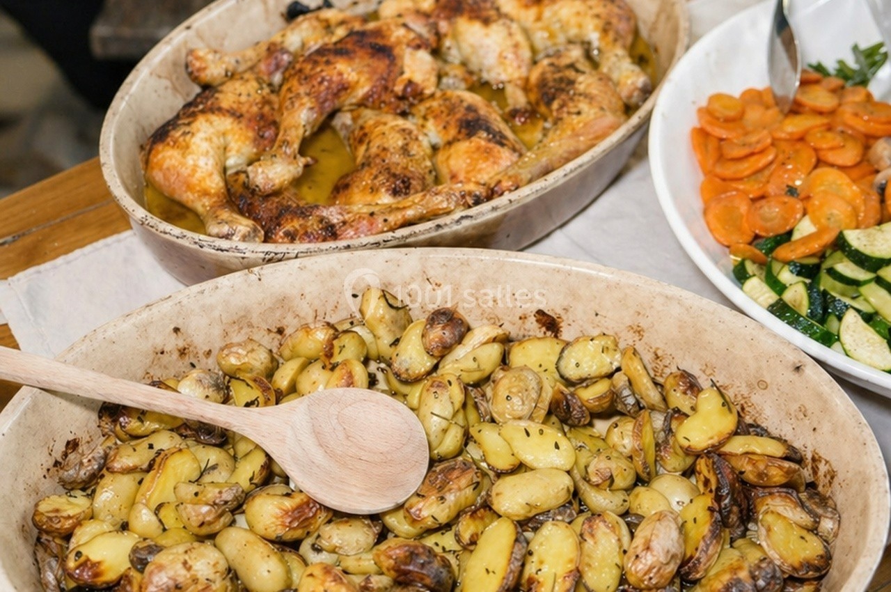 Poulet rôti dans un plat en sauce, pommes de terre rôties aux herbes et légumes sautés dans une assiette blanche.