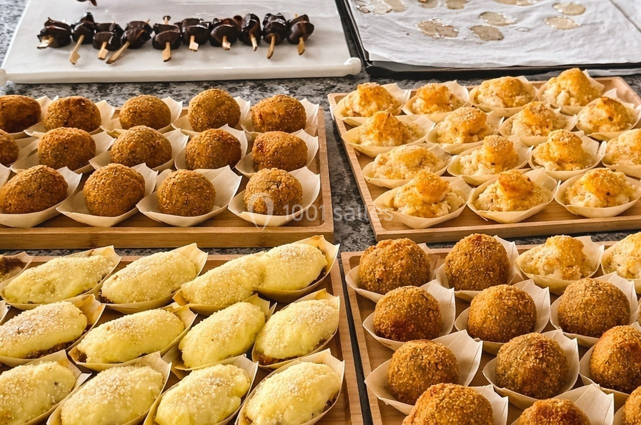 Assortiment de croquettes et bouchées salées présentées sur des plateaux en bois, prêtes à être servies.