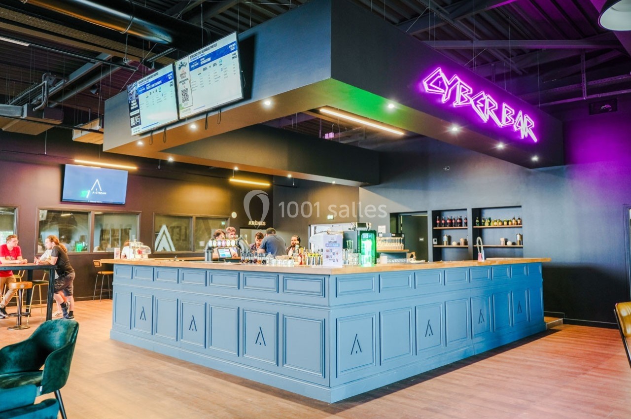 Bar moderne avec comptoir bleu, enseigne néon ’Cyberbar’, écrans d'affichage et clients en arrière-plan.