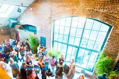 Miniature Traiteur Saint-Gilles (Bruxelles-Capitale) - La Tricoterie Traiteur #10 Une personne manipule une pâte à pizza en la faisant tourner dans un environnement de cuisine.